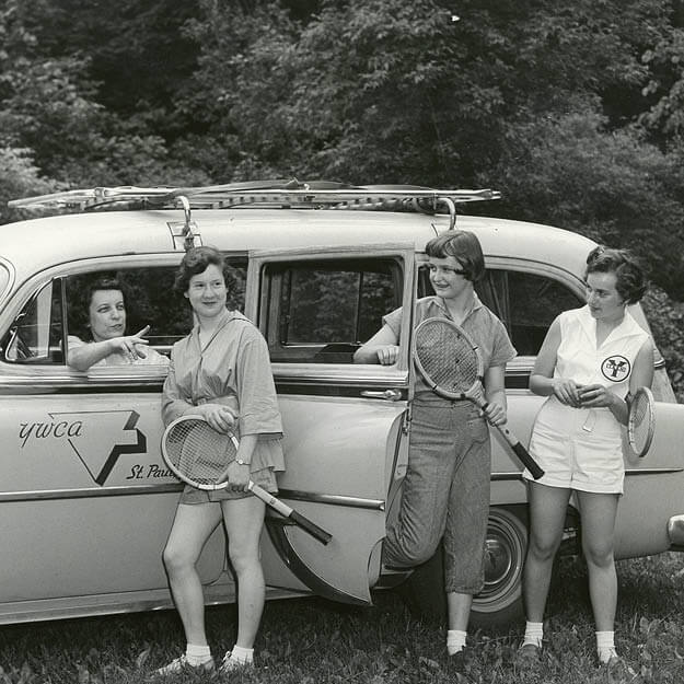 1950s photo of girls getting out of a car with tennis rackets