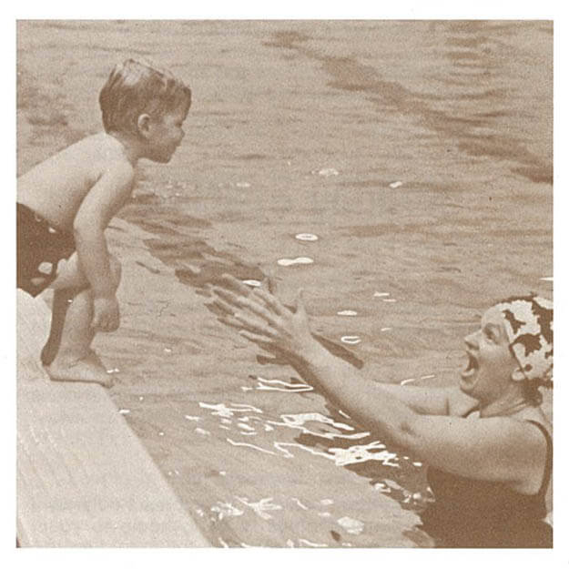 1970s photo of boy child jumping off pool ledge into his mother's arms