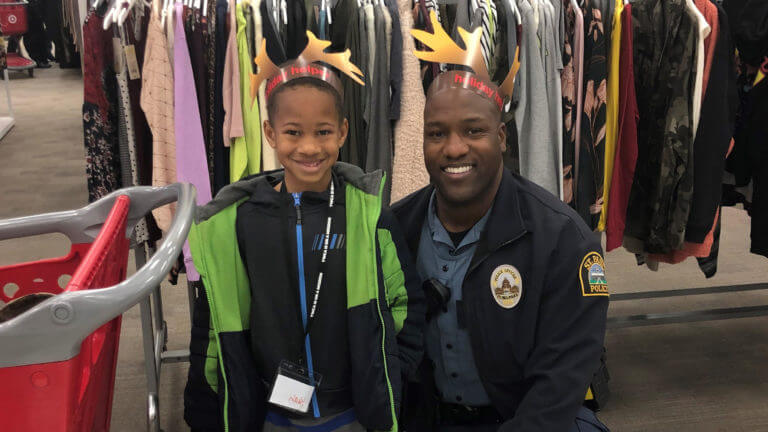 Young child and police officer pose looking at the camera and smiling