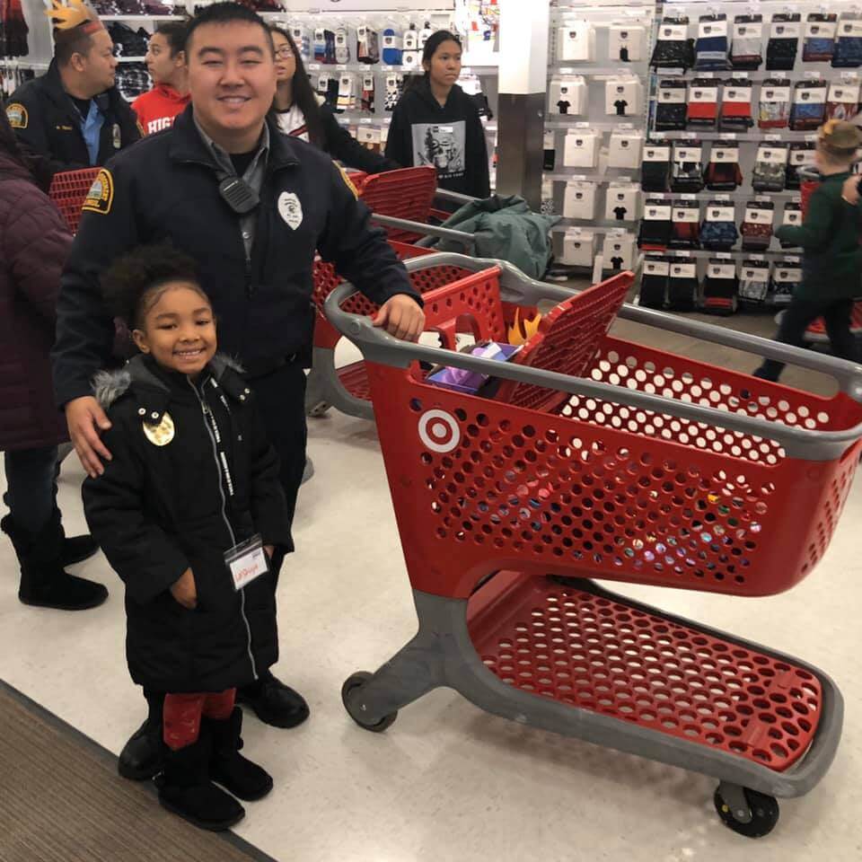 Police officer and young girl shopping at Target, smiling at the camera.