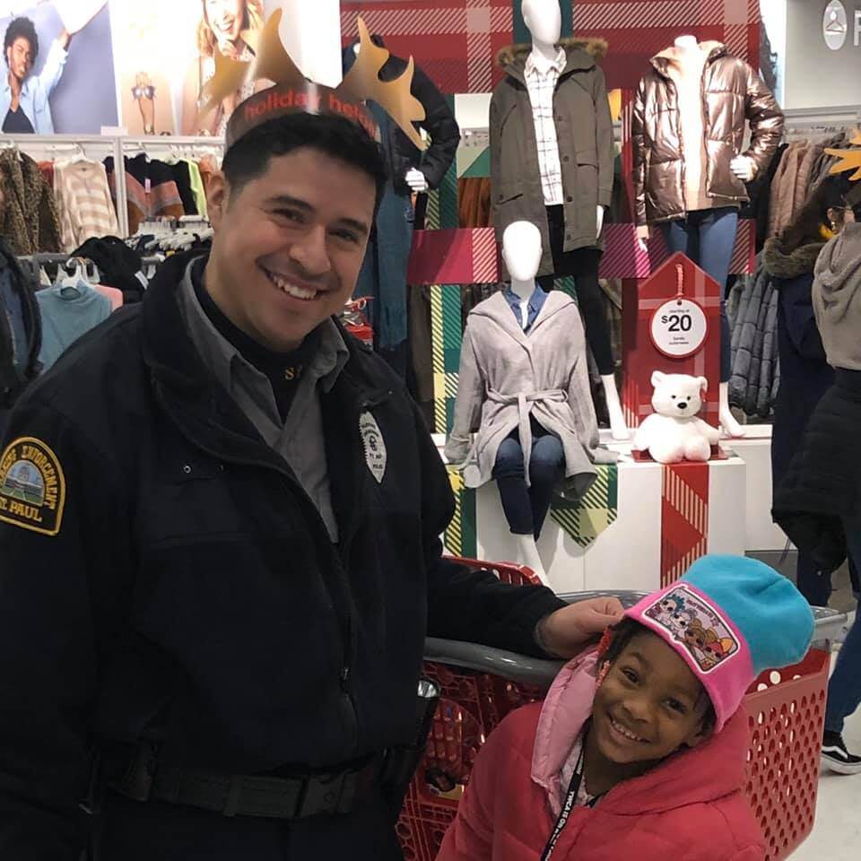 Police officer and young girl shopping at Target, smiling at the camera.