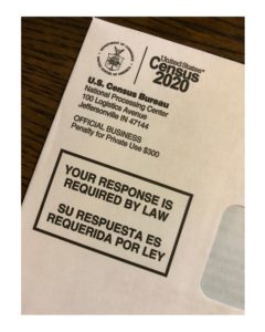 Photo of Census 2020 official mailer. Return address "National Processing Center 100 Logistics Avenue, Jeffersonville, IN 47144" "Your response is required by law"