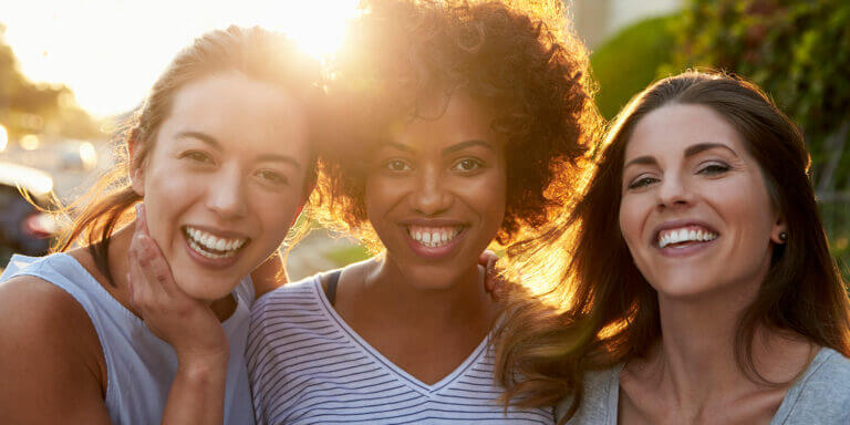 Portrait of three young adult female friends in the street