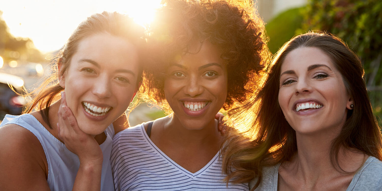 Portrait of three young adult female friends in the street