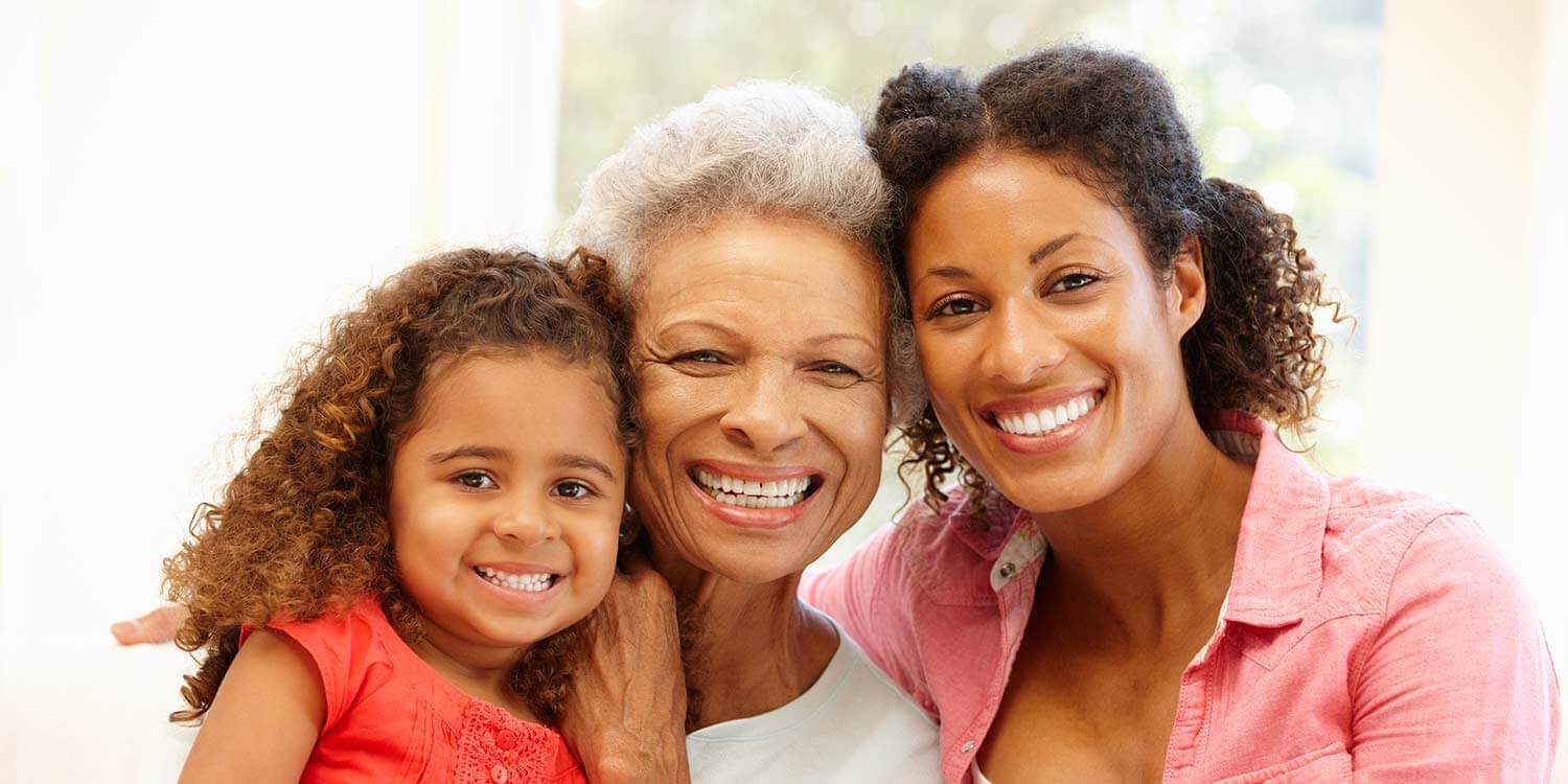 African American Mother,daughter and granddaughter at home smiling at the camera