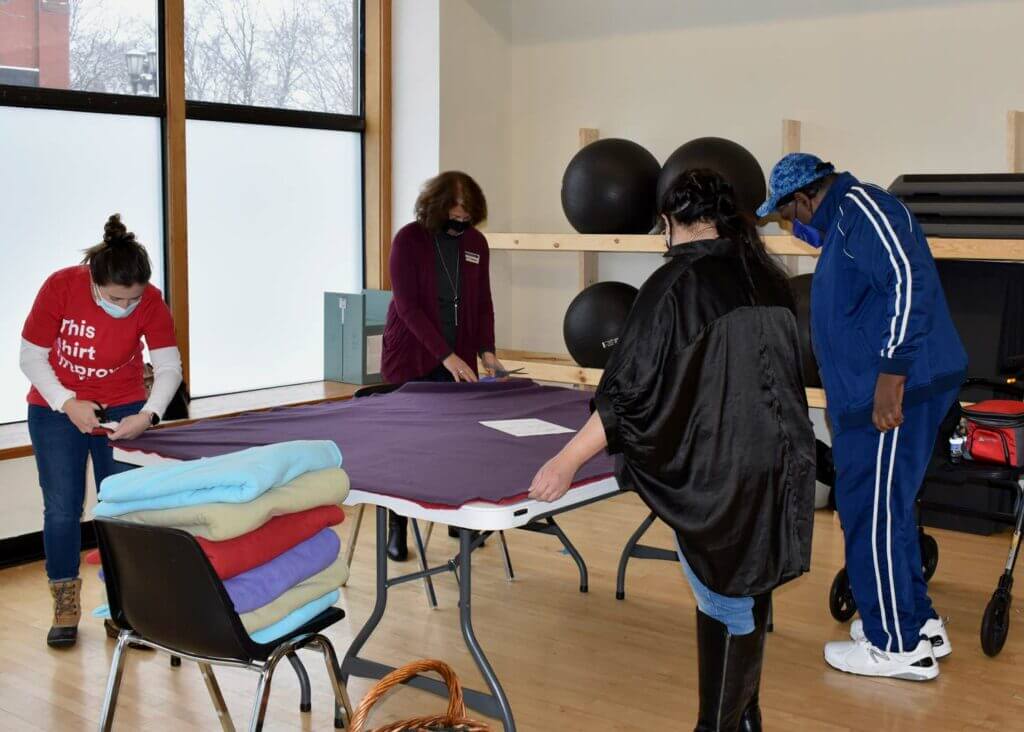 Group of volunteers working on felt blanket